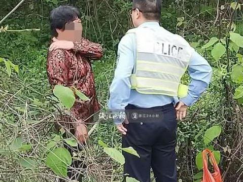 大妈在高速公路路基上挖野菜,还和交警“打哈哈”
